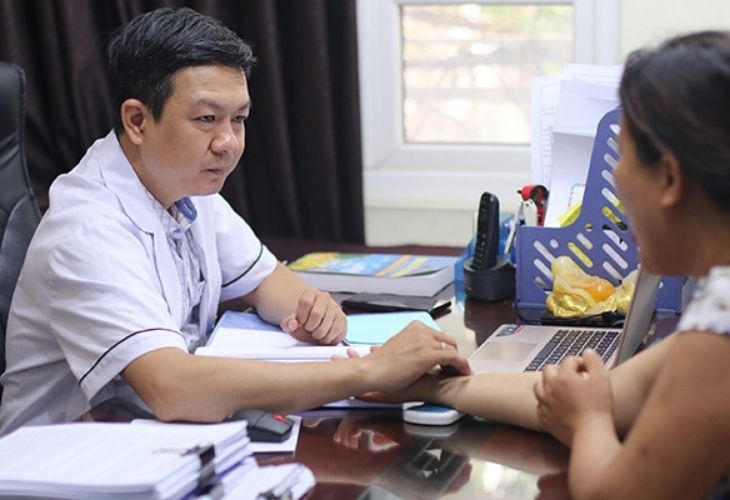 Lương y Tuấn thăm khám cho người bệnh trước khi kê đơn